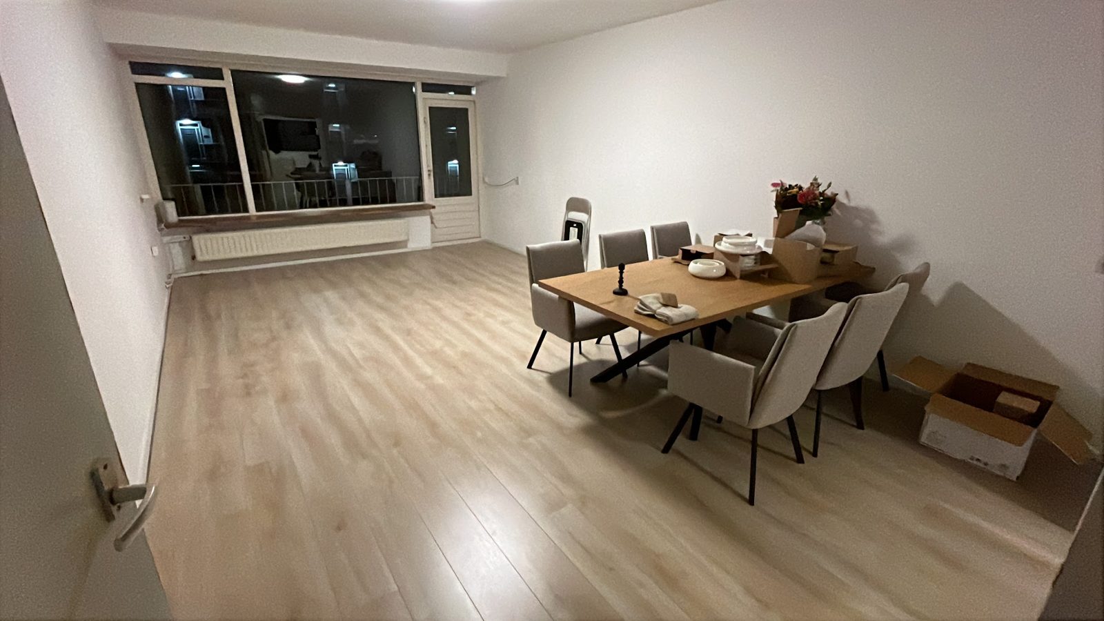 Woonkamer met nieuwe lichte laminaatvloer en eettafel