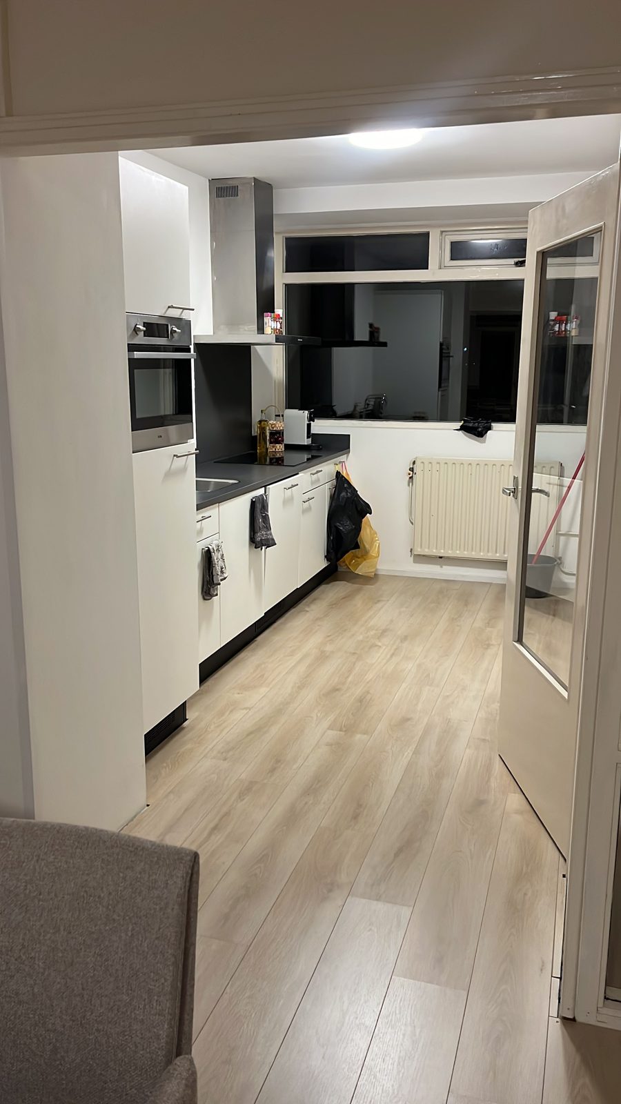 Gang naar de keuken met nieuwe lichte laminaatvloer