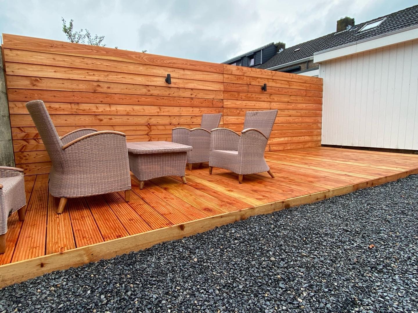 Douglas vlonder met houten schutting en tuinstoelen na een complete tuinrenovatie